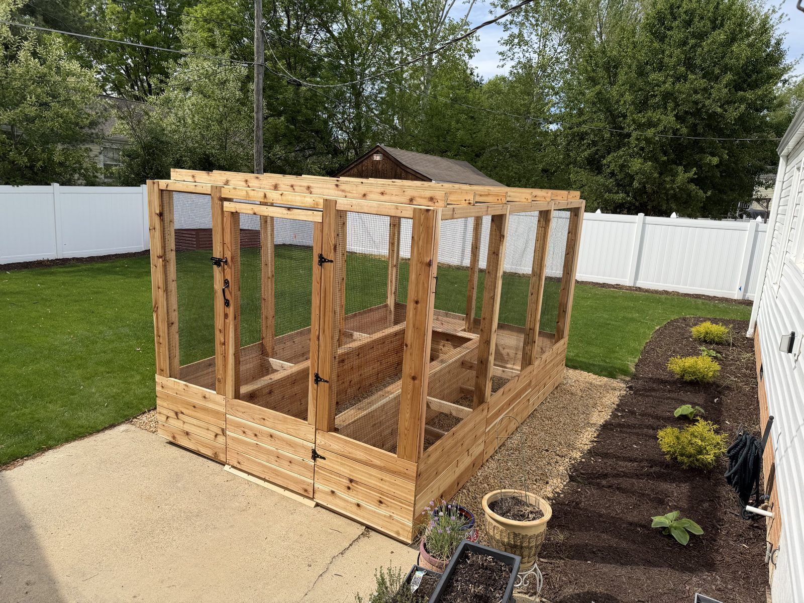 Cedar X Change enclosed garden system installed beside a home